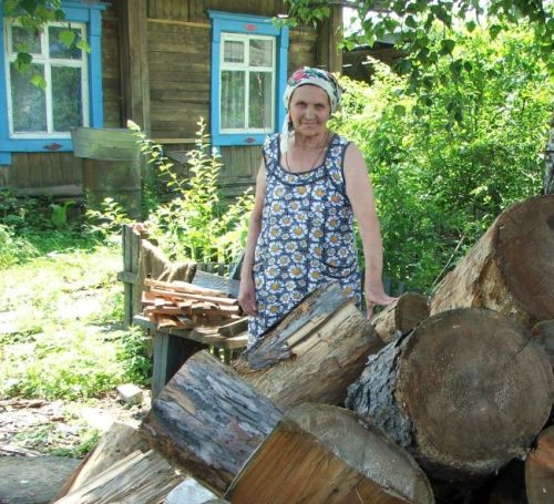 Галина Сусская на фоне остатков дров в ее дворе