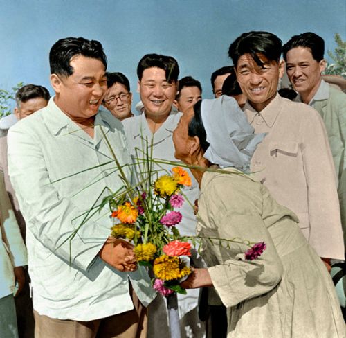 -- Ким Ир Сен принимает букет цветов от пожилой женщины в Чоянском сельхозкооперативе в уезде Хамчжу (август 49 г. чучхе (1960). Фото ЦТАК