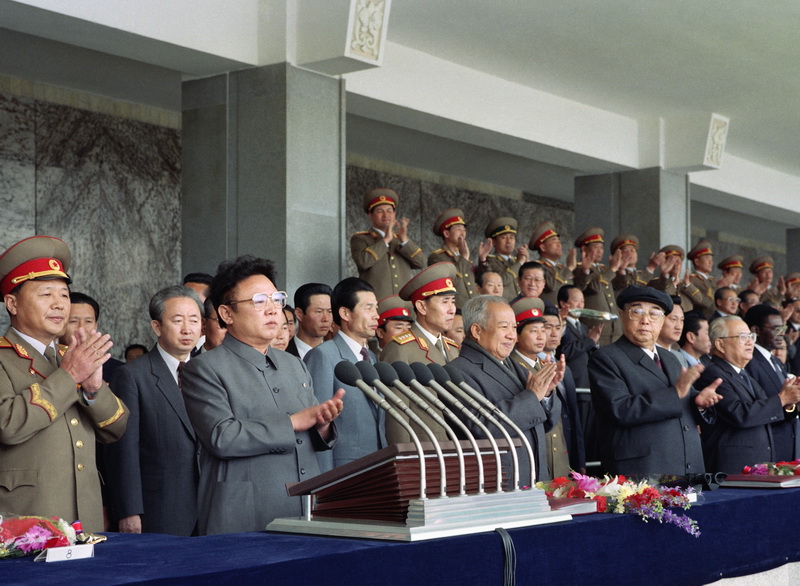 Великий Ким Ир Сен и великий Ким Чен Ир на трибуне военного парада в честь 60-летия КНРА. Апрель 1992 года.